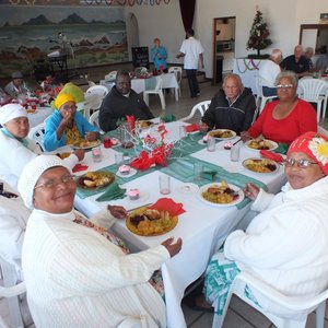 ‘n Gesellige oomblik aan tafel tydens die NG Vrouediens se Uitreikaksie se jaarlikse Kersete aan die bejaardes van Silwerjare Dienssentrum